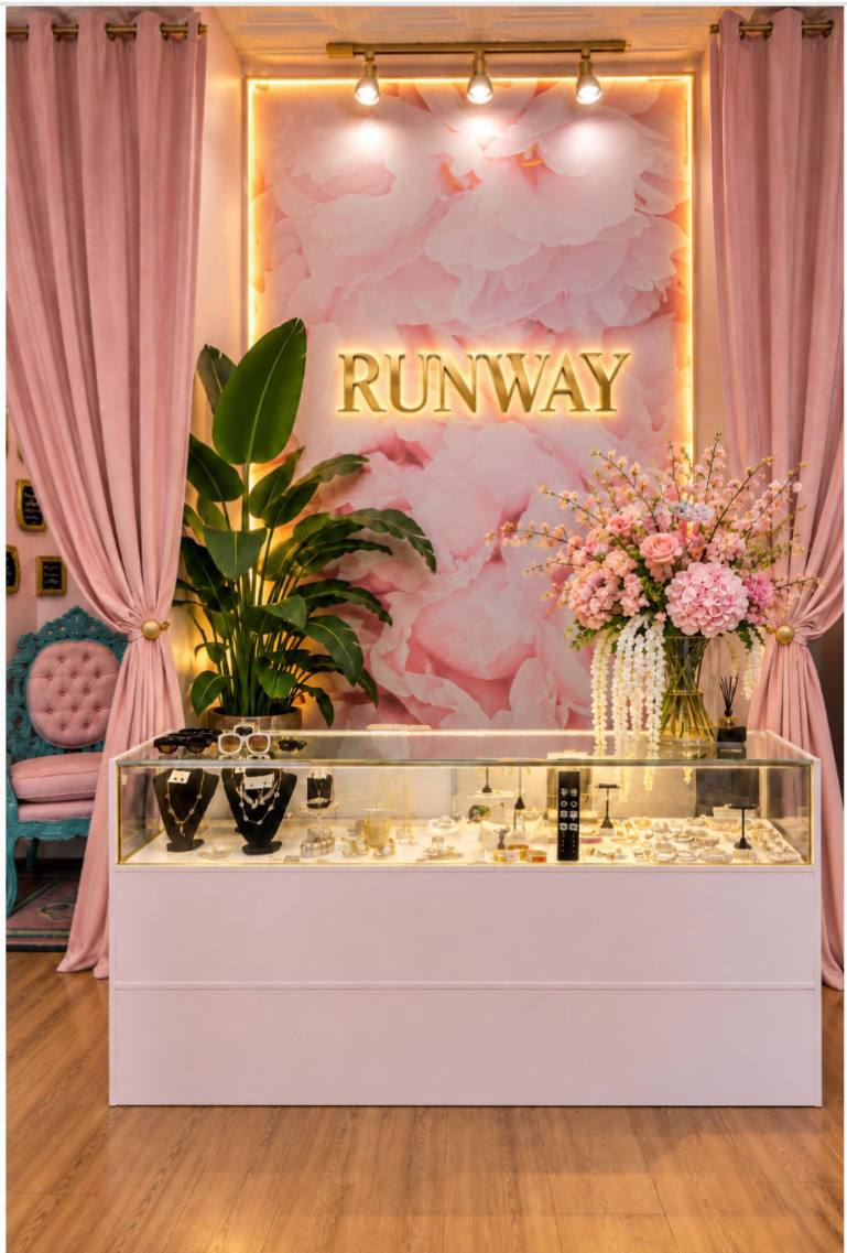Inside Runway Boutique: the blush-pink jewelry counter beneath the glowing RUNWAY sign